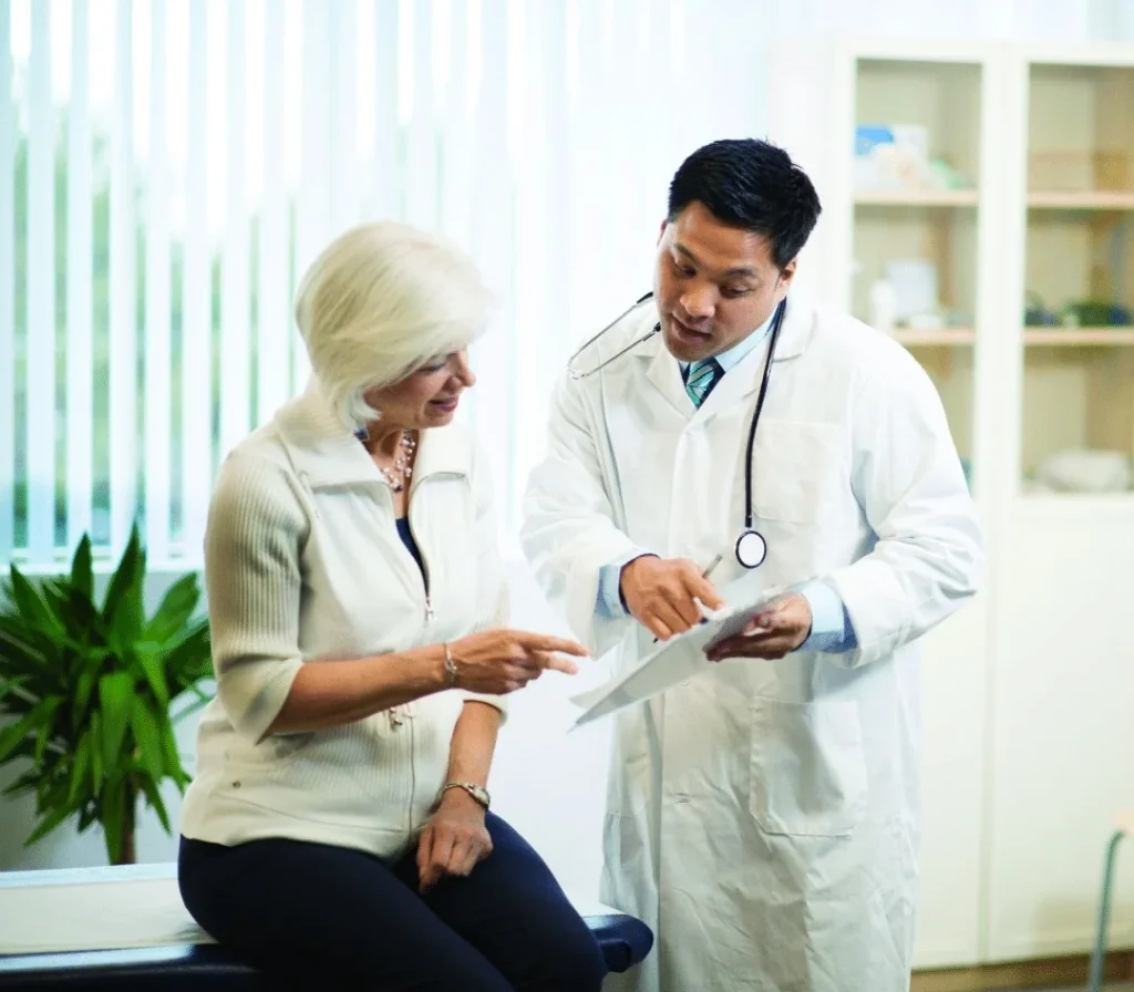 patient talking to a doctor w/ a clipboard