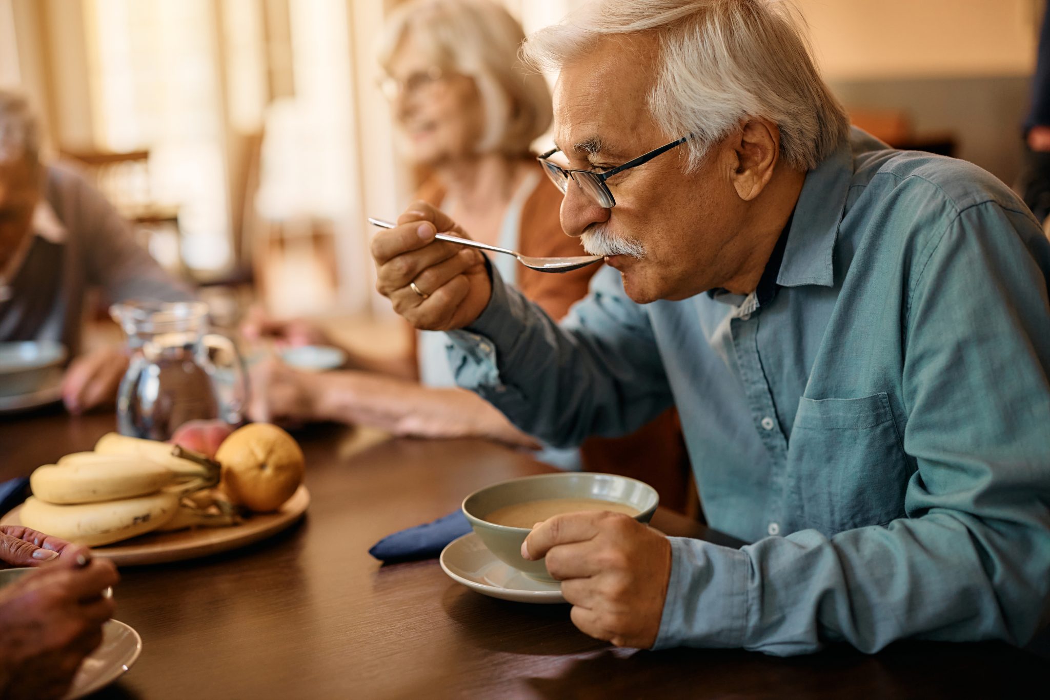 Senior man eating lunch at nursing home.